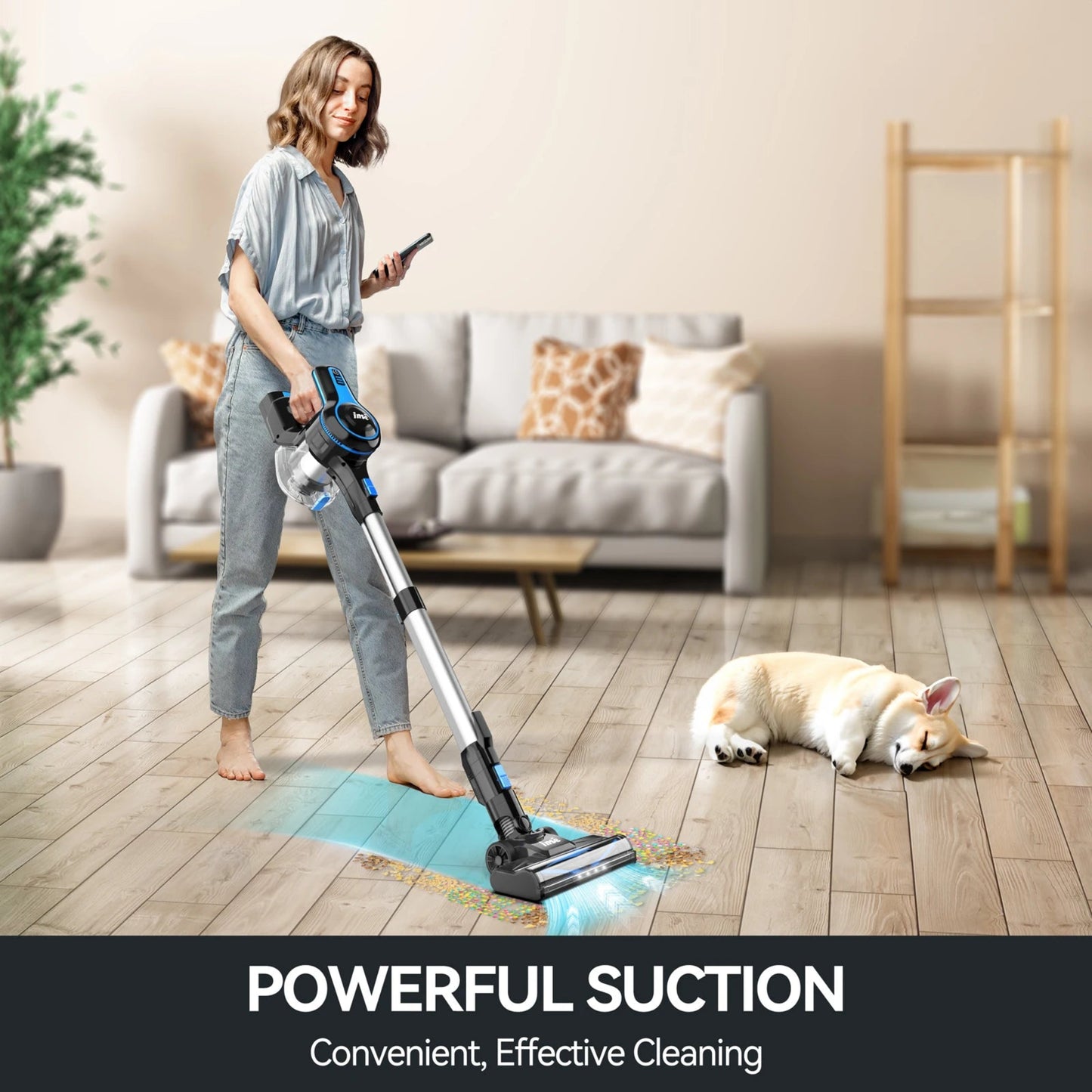 Woman using a cordless vacuum cleaner in a living room with a dog lying on the floor.