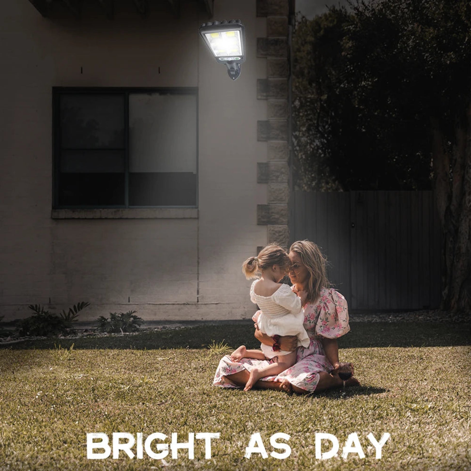 Woman and child sitting on grass in front of a house with a light fixture, text 'BRIGHT AS DAY'.