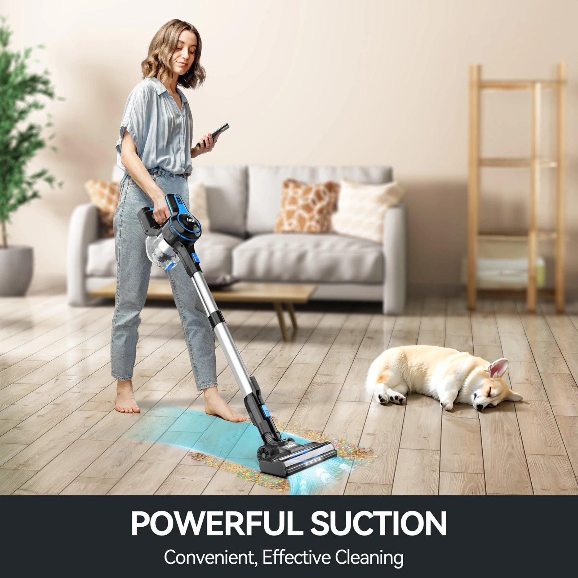 Woman using a cordless vacuum cleaner in a living room with a dog lying on the floor.