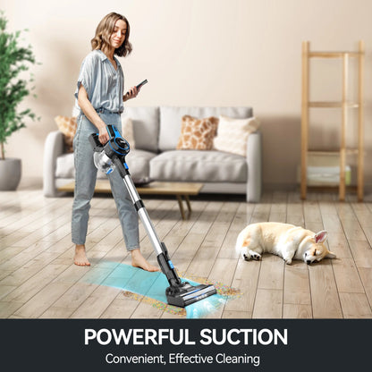 Woman using a cordless vacuum cleaner in a living room with a dog lying on the floor.